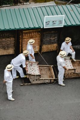 Monte sledge drivers in traditional attire preparing for the ride in Funchal, Madeira.