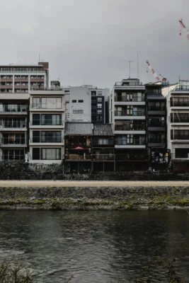 Scenic view of traditional Kyoto buildings along a calm river, capturing the cultural essence.